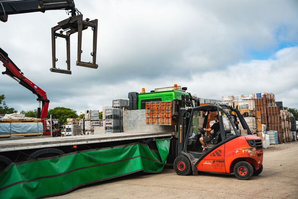 Forklift loading a flatbed lorry in the yard