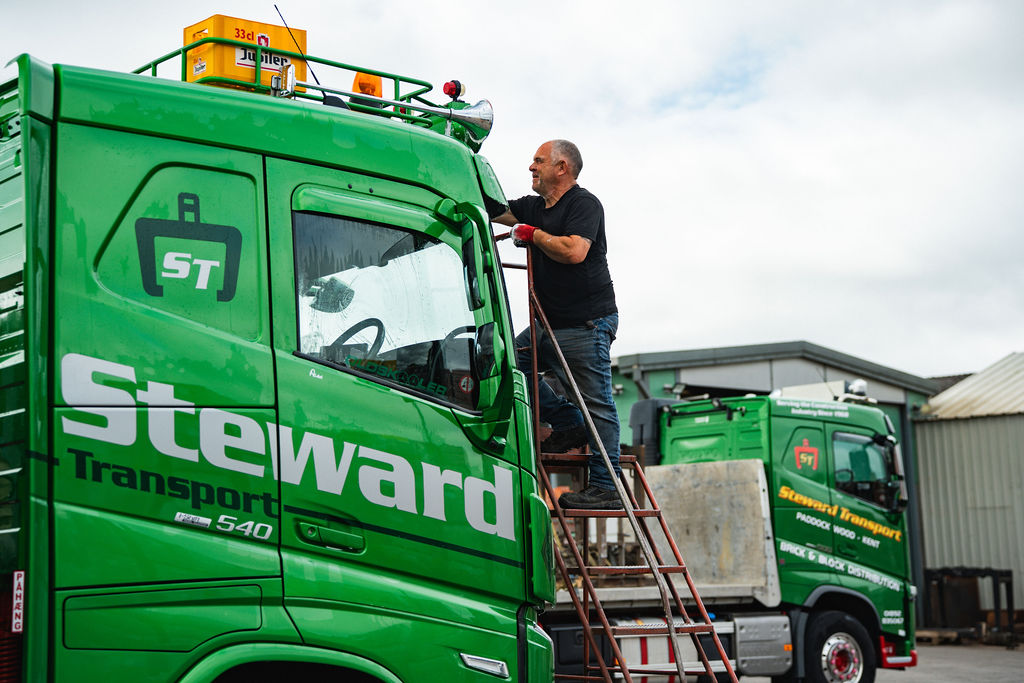 Driver climbing into a Steward Transport lorry