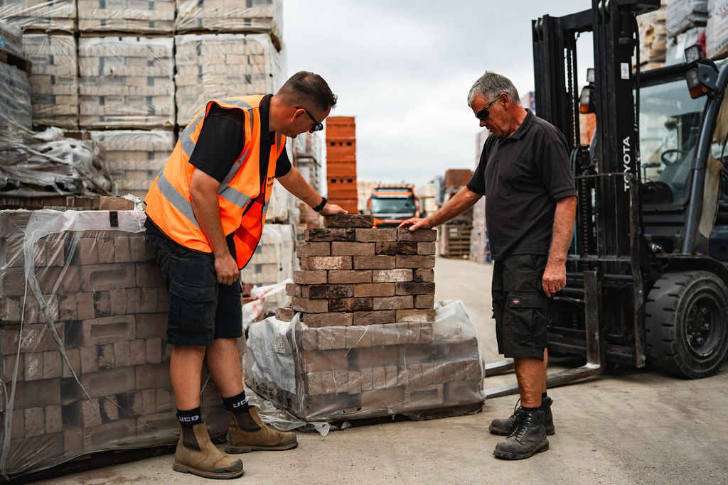 Staff and a customer comparing bricks from a pack