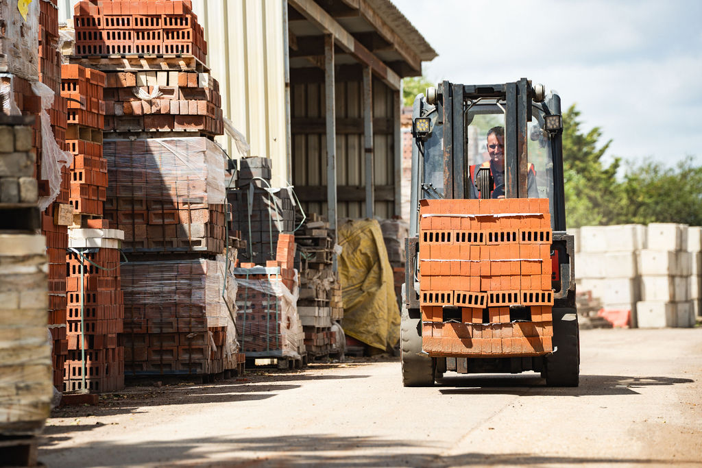 Forklift lifting bricks under the canopy