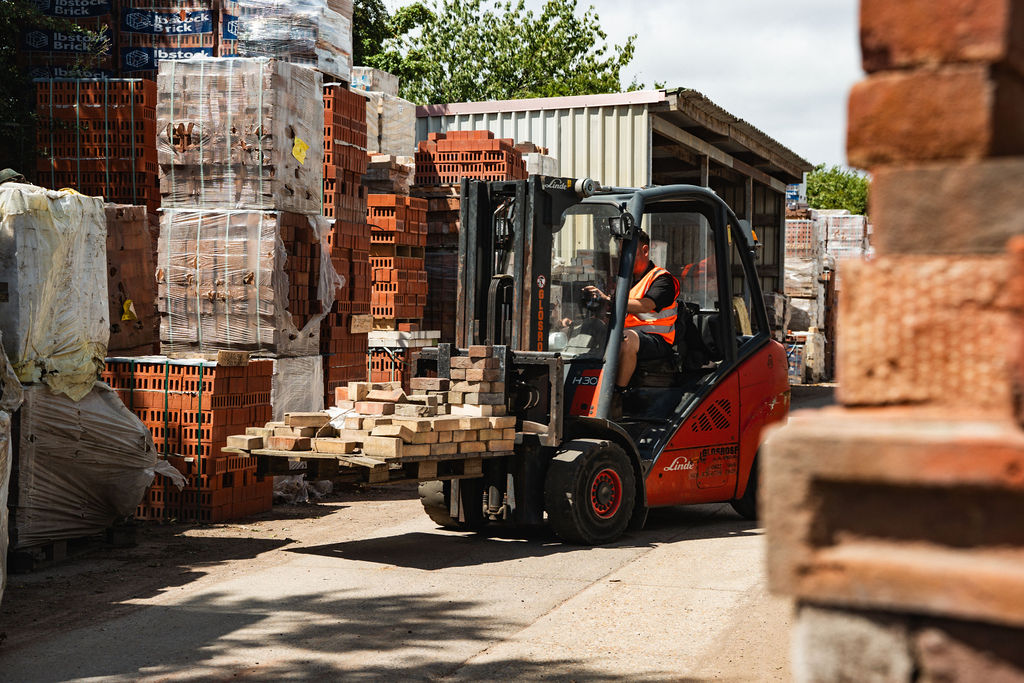 Forklift at work beside stacked brick packs