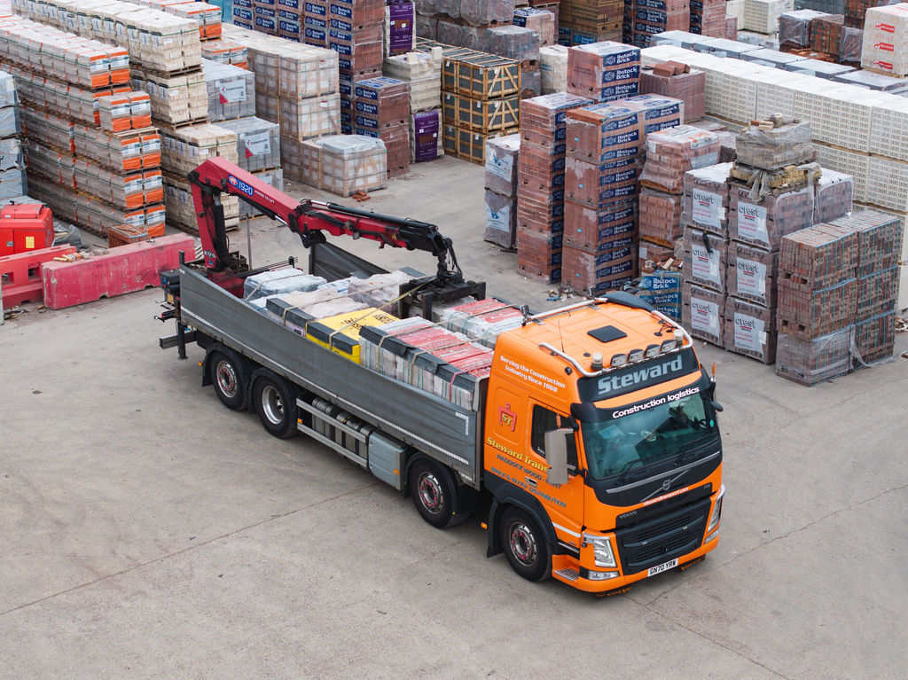 Loaded lorry viewed from above leaving the yard